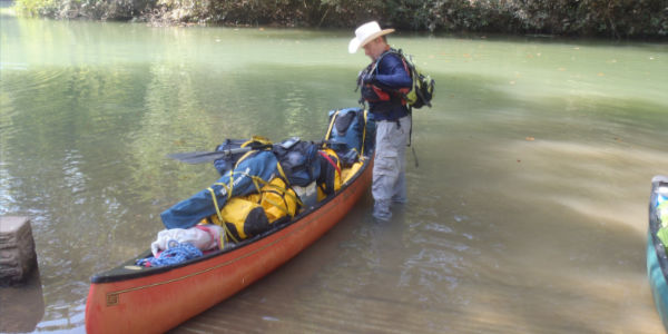 The bow of a kayak, looking out onto the river