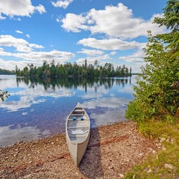 The bow of a kayak, looking out onto the river